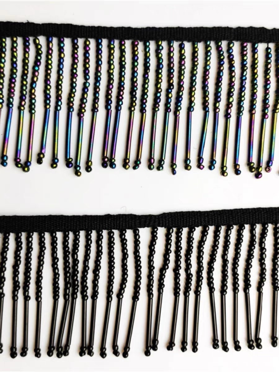 Handgemaakte kralenfranje van 90 cm lang en 6 cm breed, gemaakt van irisblauwe zaadkralen en lange buiskralen. Geschikt als lampenkapfranje, jurkfranje of voor het zelf naaien van kralen.