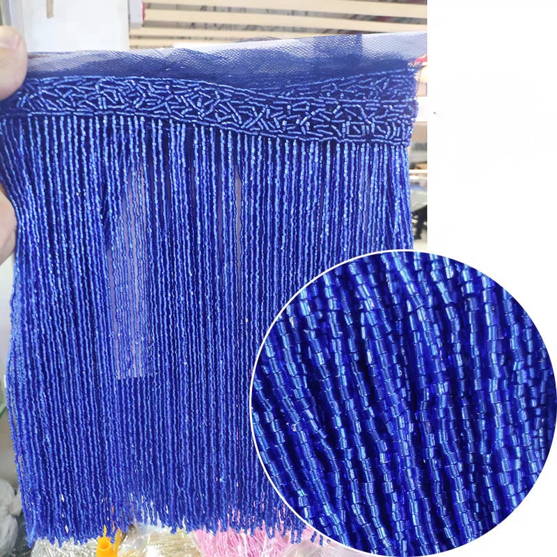 Handgemaakte kralenfranje van 180 cm lang en 25 cm breed, gemaakt van 2 gesneden zaadkralen. Geschikt als franje voor lampenkappen, trouwjurken, kostuums, doe-het-zelf decoratie of kwastjes. Verkrijgbaar in 10 verschillende kleuren.
