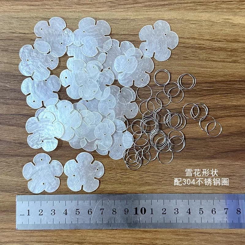 50 disques de nacre naturelle, transparents, en forme d'arbre, de papillon, de cœur, de larme et de fleur.