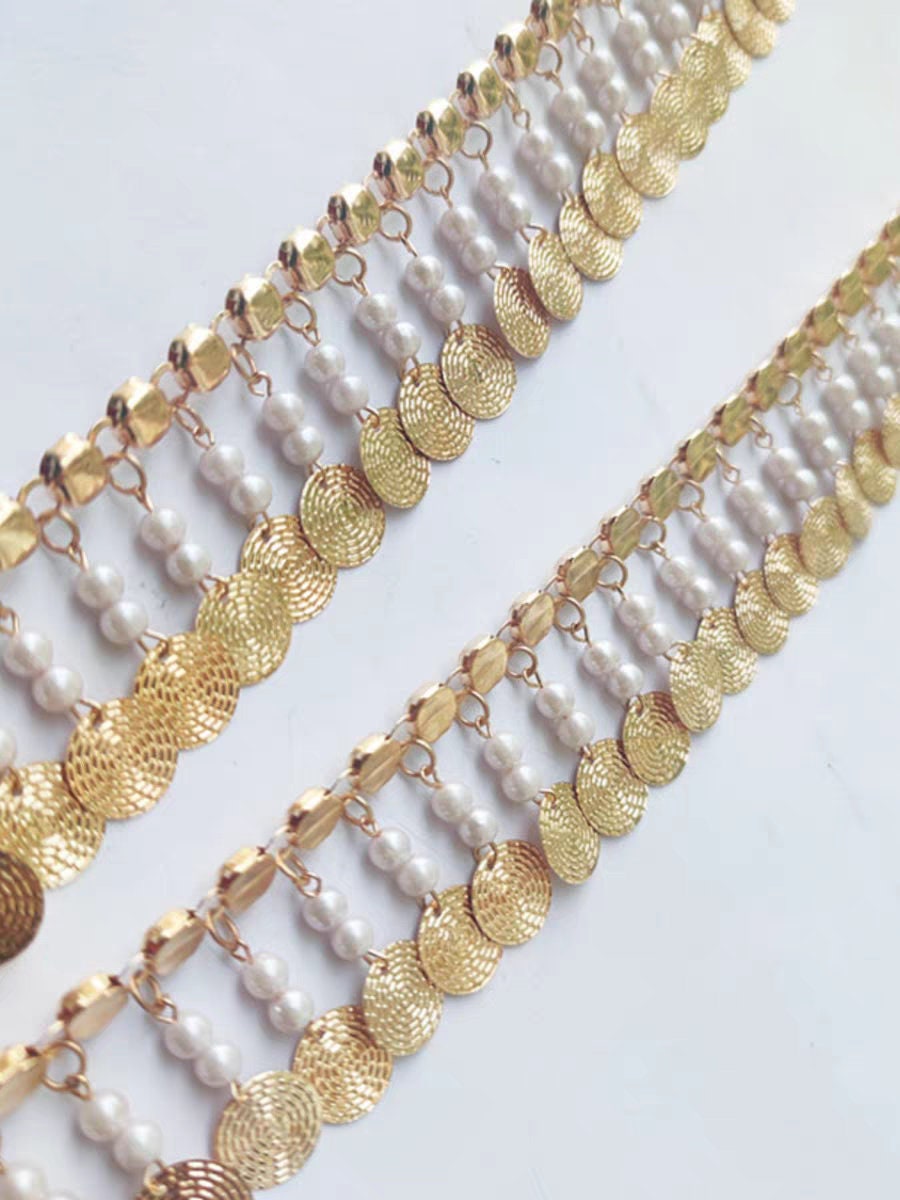 Frange faite à la main, de 91 cm de long et 4 cm de large, ornée de perles et de sequins métalliques dorés.