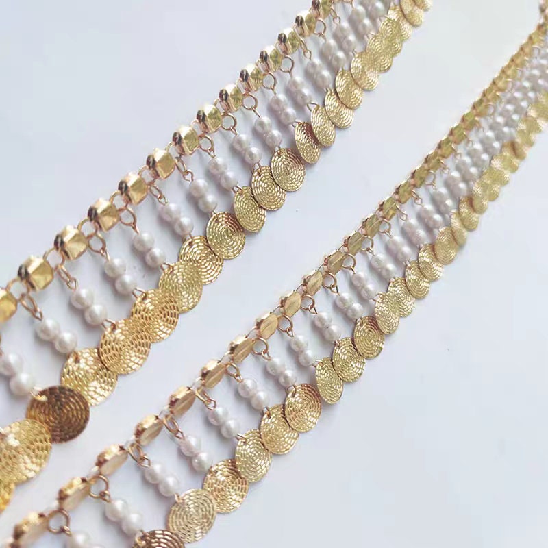 Frange faite à la main, de 91 cm de long et 4 cm de large, ornée de perles et de sequins métalliques dorés.