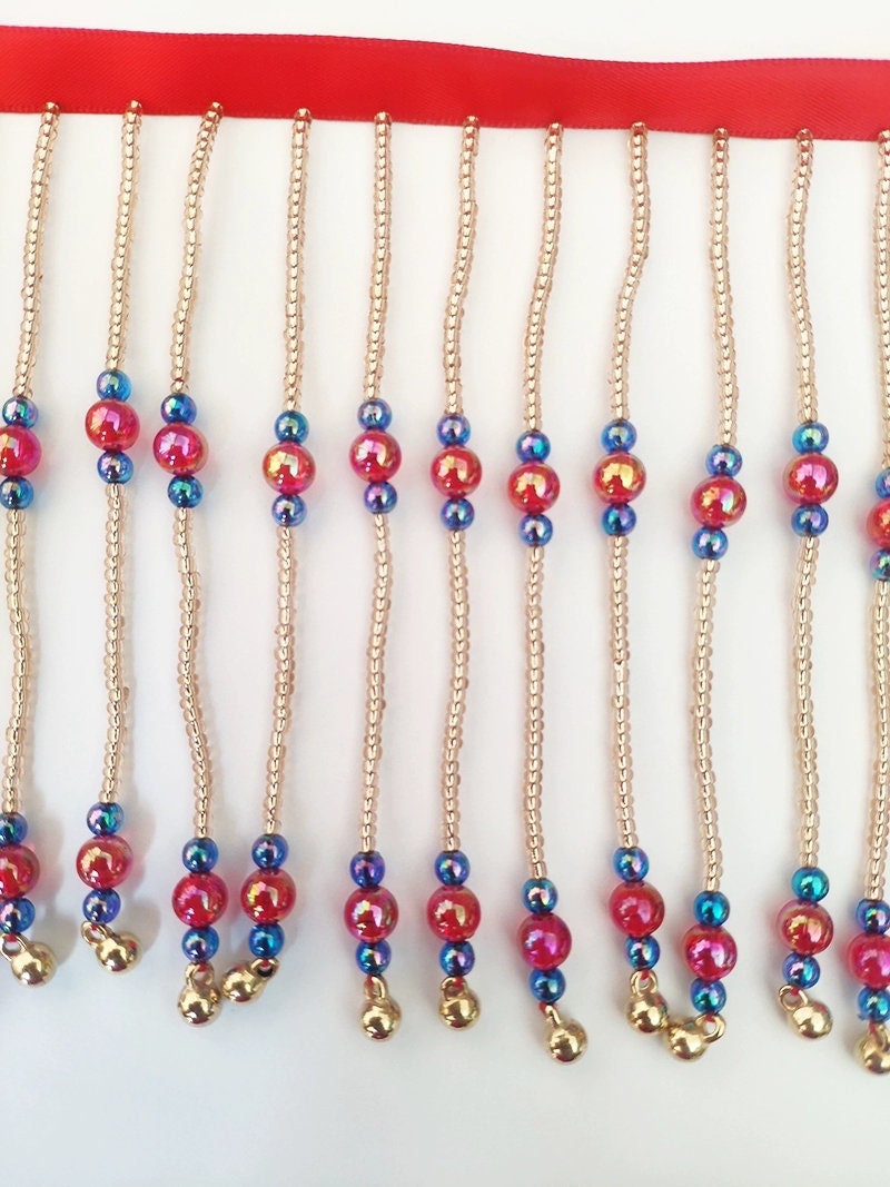 Frange perlée faite main, 90 cm de long x 10 cm de large, composée de perles rouges brillantes et de clochettes. Idéale pour abat-jour ou à réaliser soi-même.