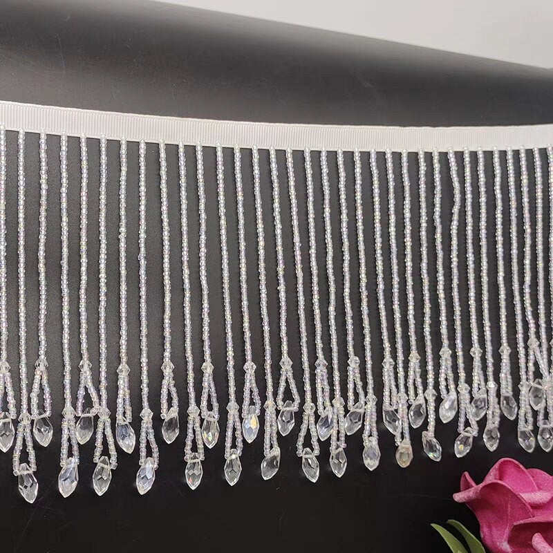 Handgemaakte kralenfranje van 12 cm brede kristallen kralen en kleine kraaltjes, goudkleurig en kristalhelder.