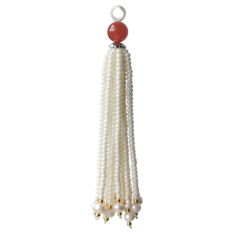 Perles artisanales de 8 à 9 cm de long, ornées de perles et de pierres précieuses émaillées, avec franges et pompons.
