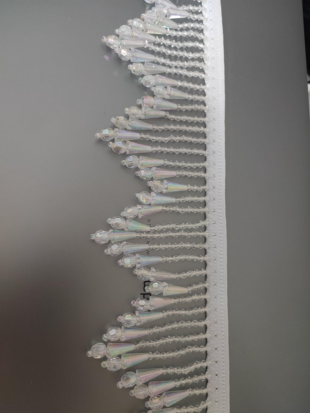 Handgemaakte franje van 1 meter lange en 8 cm brede iriskralen van transparant plastic met een chevronpatroon, geschikt voor lampenkappen, gordijnen, naaiprojecten en decoratie.