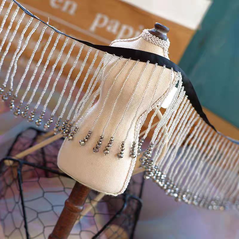 Frange perlée faite main de 90 cm de long et 10,5 cm de large, ornée de perles de rocaille et de perles de cristal. Idéale pour abat-jour, robe de mariée ou rideau.