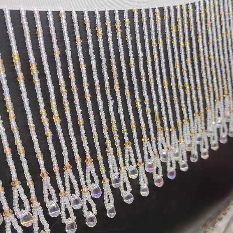 Handgemaakte kralenfranje van 12 cm brede kristallen kralen en kleine kraaltjes, goudkleurig en kristalhelder.