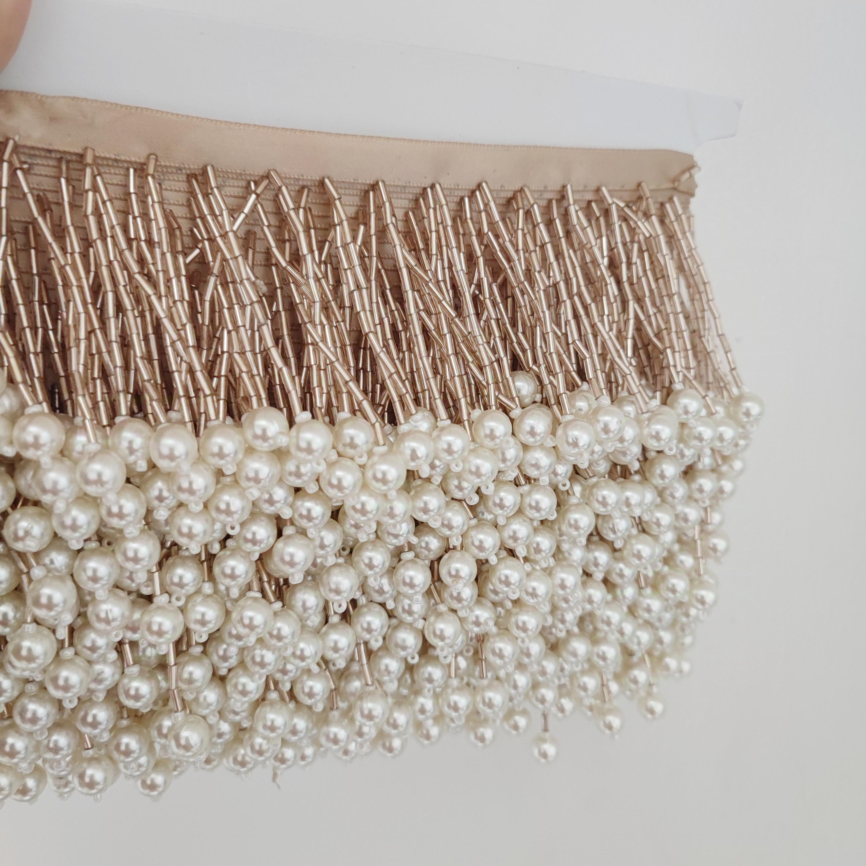 Frange perlée faite main de 90 cm de long et 8 cm de large, composée de perles tubulaires et de perles de culture. Idéale pour abat-jour, rideaux, robes, etc.