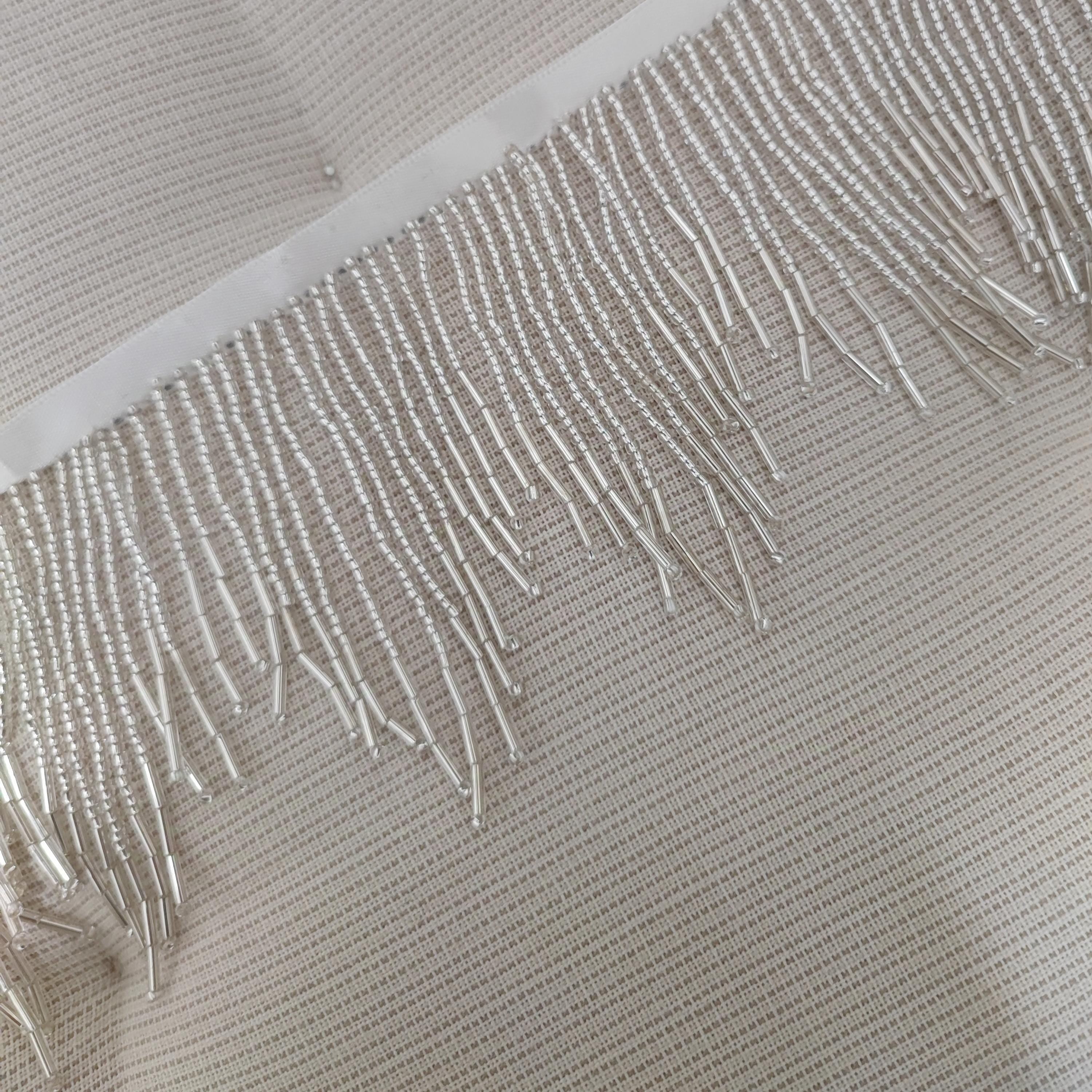 Frange perlée de 90 cm de long et de 5 à 7 cm de large, disponible en argent, or et couleurs personnalisées.