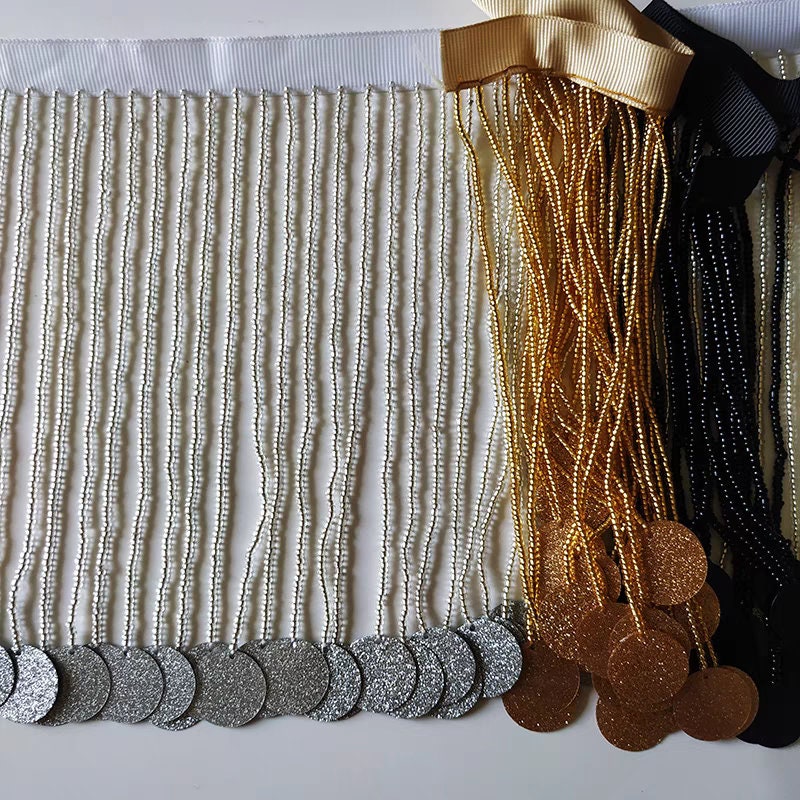 Frange perlée de 15 cm de large avec sequins et perles, idéale pour décorer robes, costumes et abat-jour. Couleurs disponibles : argent, or, vert, noir, rouge, marron. Possibilité de personnalisation (autres couleurs).