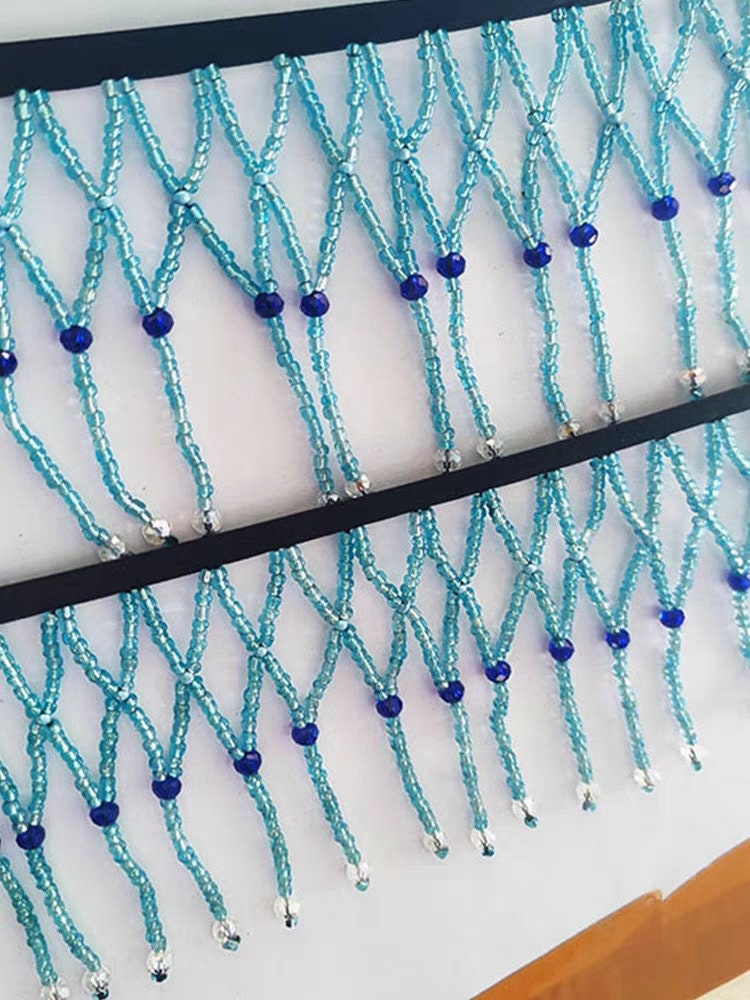 Handgemaakte, 90 cm lange en 10 cm brede, hemelsblauwe gevlochten franje met kralen, geschikt als lampenkapjurk of franje. DIY knutselproject met kralen en franje.