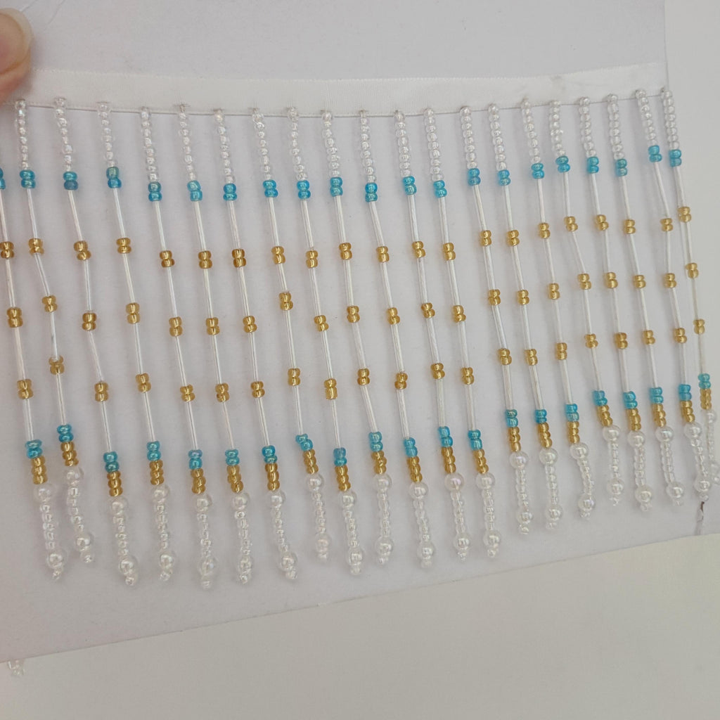 Handgemaakte lampenkapfranje van 90 cm lang en 11,5 cm breed met iriskralen in de kleuren helder, goud en turkooizen.