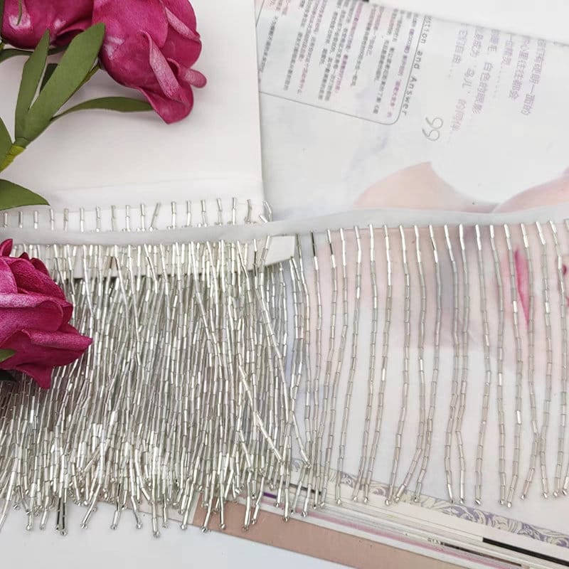 Frange perlée entièrement composée de perles tubulaires, 90 cm de long et 10 cm de large. Idéale pour la décoration de robes et costumes, ou pour abat-jour. Disponible en 10 couleurs différentes.