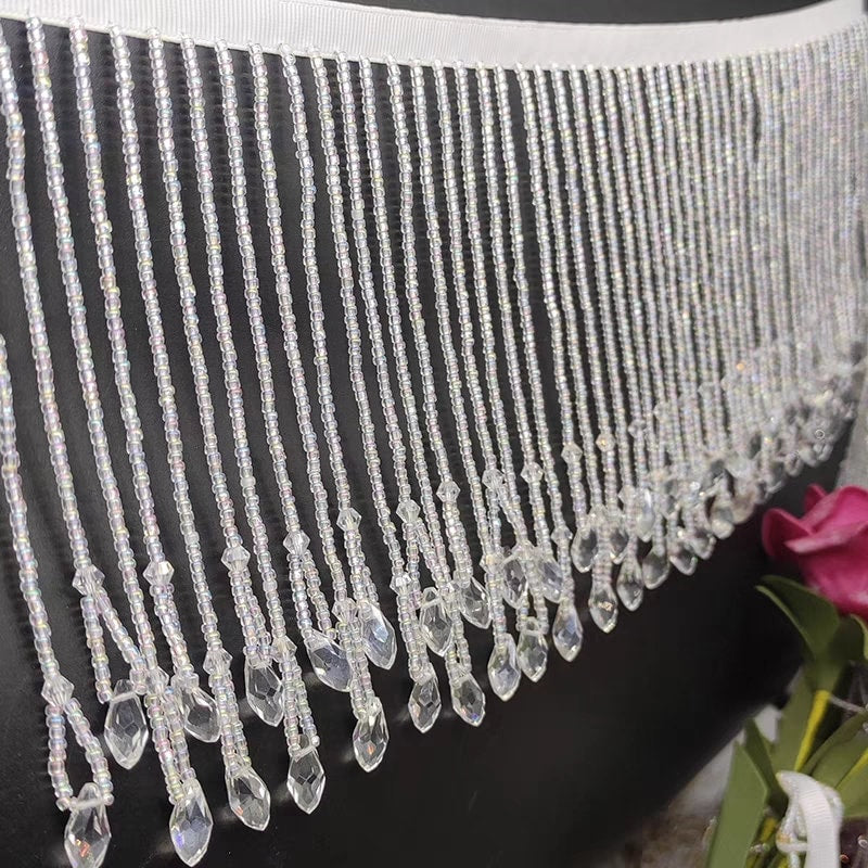 Handgemaakte kralenfranje van 12 cm brede kristallen kralen en kleine kraaltjes, goudkleurig en kristalhelder.