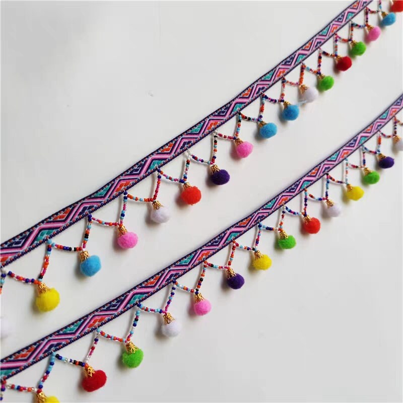 Handgemaakte pompon met kralenfranje, 90 cm lang en 3 cm breed.