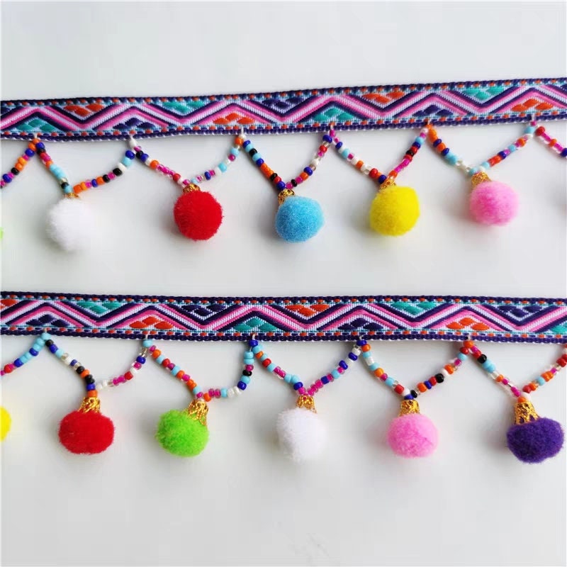 Handgemaakte pompon met kralenfranje, 90 cm lang en 3 cm breed.