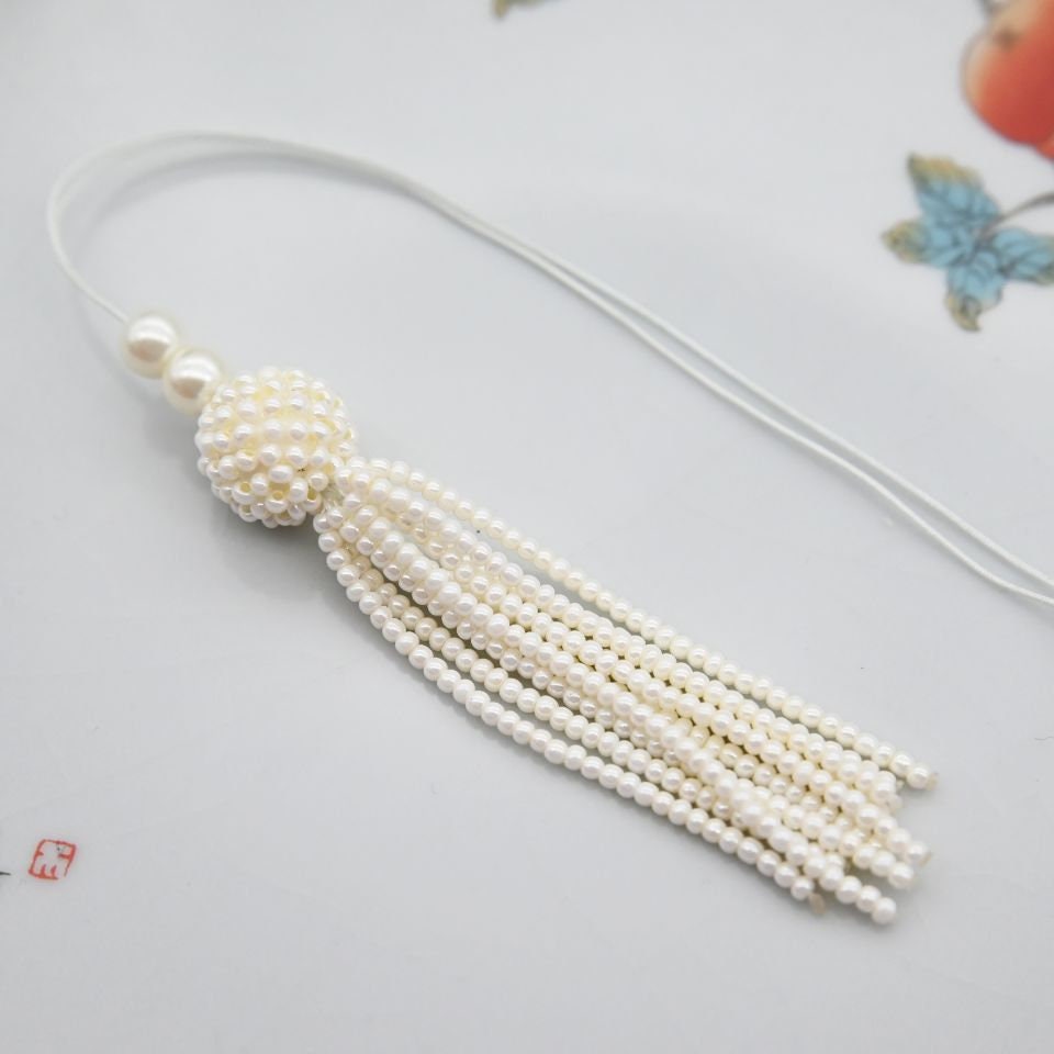 Handgemaakte 8,5 cm lange hanger met parelkralen en kwastje.