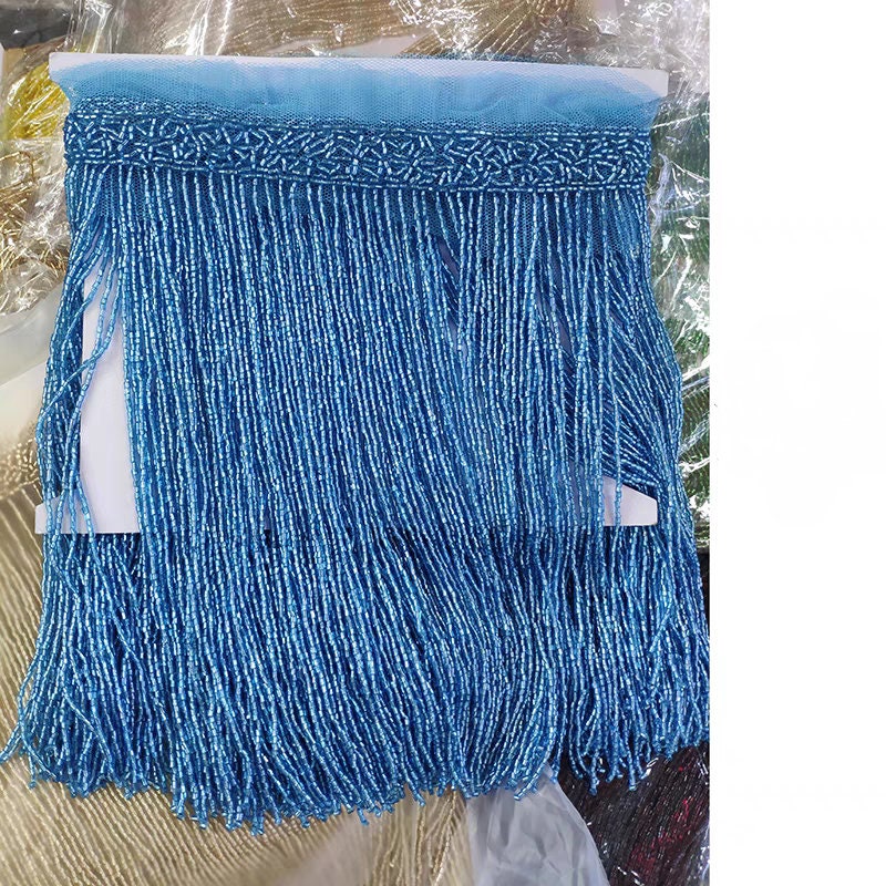 Handgemaakte kralenfranje van 180 cm lang en 25 cm breed, gemaakt van 2 gesneden zaadkralen. Geschikt als franje voor lampenkappen, trouwjurken, kostuums, doe-het-zelf decoratie of kwastjes. Verkrijgbaar in 10 verschillende kleuren.