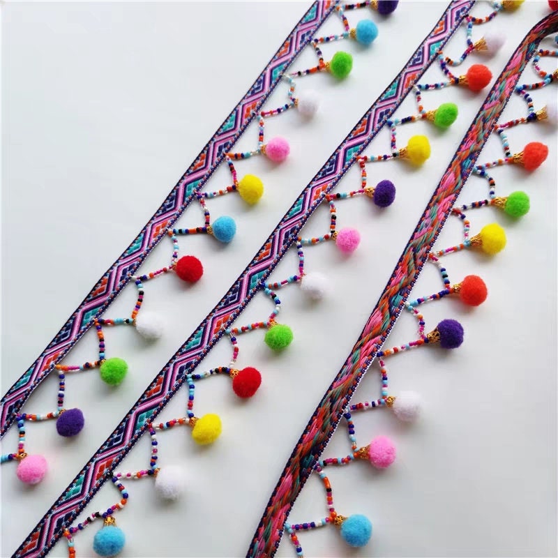 Handgemaakte pompon met kralenfranje, 90 cm lang en 3 cm breed.