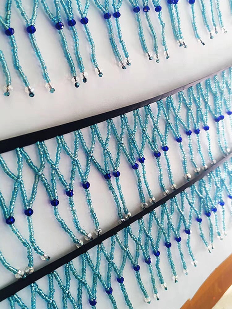 Handgemaakte, 90 cm lange en 10 cm brede, hemelsblauwe gevlochten franje met kralen, geschikt als lampenkapjurk of franje. DIY knutselproject met kralen en franje.