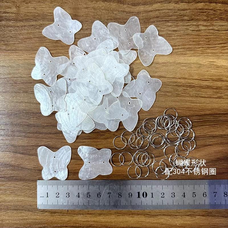 50 disques de nacre naturelle, transparents, en forme d'arbre, de papillon, de cœur, de larme et de fleur.