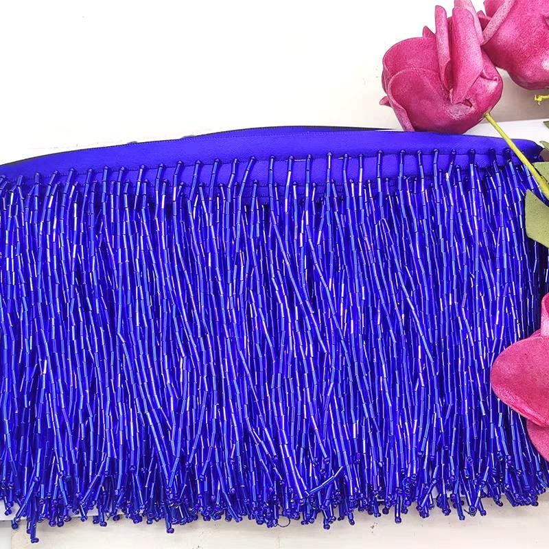 Frange perlée entièrement composée de perles tubulaires, 90 cm de long et 10 cm de large. Idéale pour la décoration de robes et costumes, ou pour abat-jour. Disponible en 10 couleurs différentes.