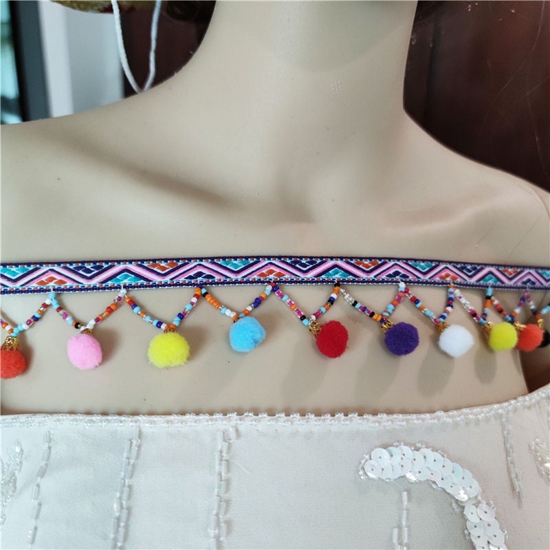 Handgemaakte pompon met kralenfranje, 90 cm lang en 3 cm breed.