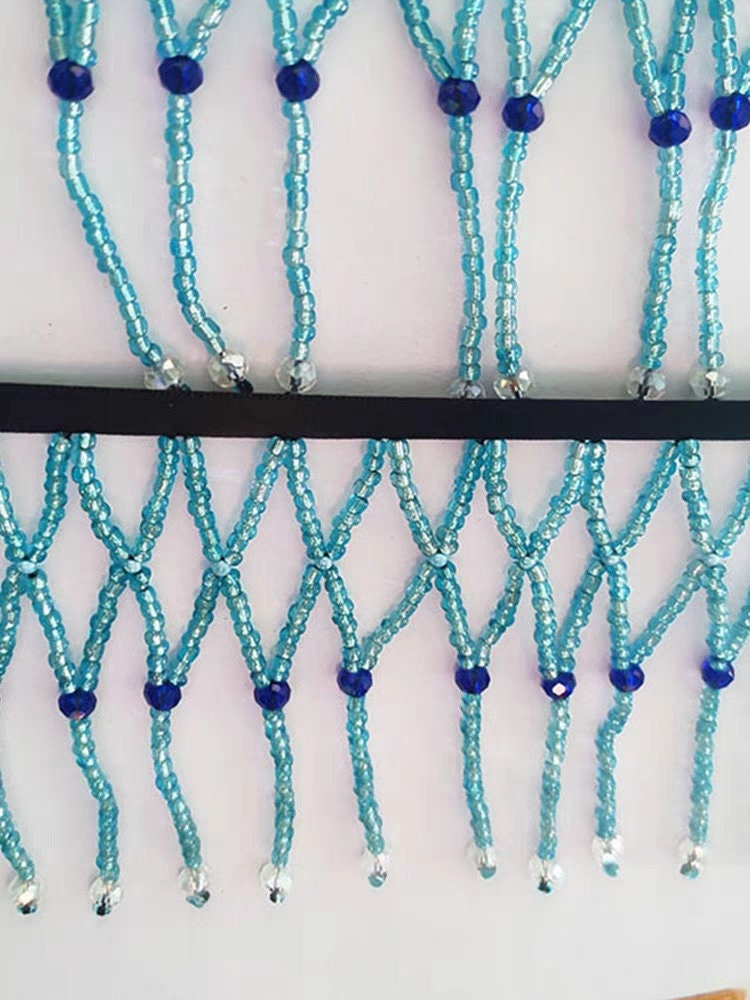 Handgemaakte, 90 cm lange en 10 cm brede, hemelsblauwe gevlochten franje met kralen, geschikt als lampenkapjurk of franje. DIY knutselproject met kralen en franje.