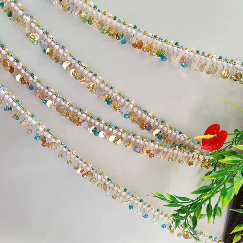 Handgemaakte kralenketting met franjes van kristallen kralen en metalen pailletten, 90 cm lang en 3 cm breed.