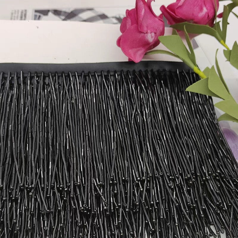 Frange perlée entièrement composée de perles tubulaires, 90 cm de long et 10 cm de large. Idéale pour la décoration de robes et costumes, ou pour abat-jour. Disponible en 10 couleurs différentes.
