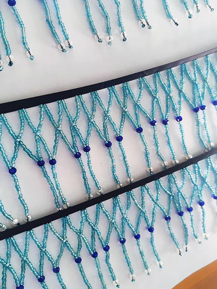 Handgemaakte, 90 cm lange en 10 cm brede, hemelsblauwe gevlochten franje met kralen, geschikt als lampenkapjurk of franje. DIY knutselproject met kralen en franje.