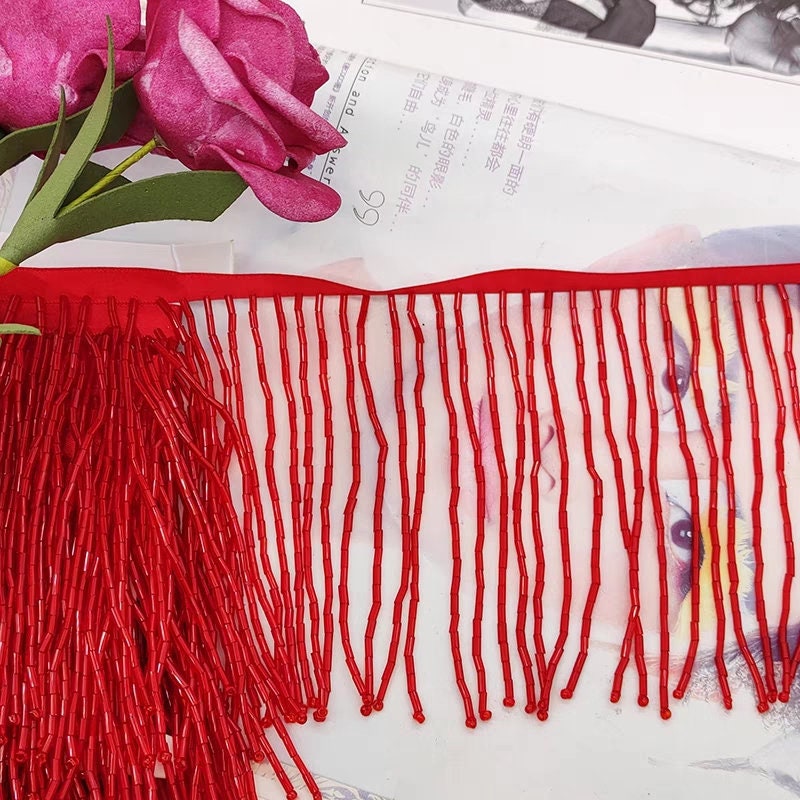 Frange perlée entièrement composée de perles tubulaires, 90 cm de long et 10 cm de large. Idéale pour la décoration de robes et costumes, ou pour abat-jour. Disponible en 10 couleurs différentes.