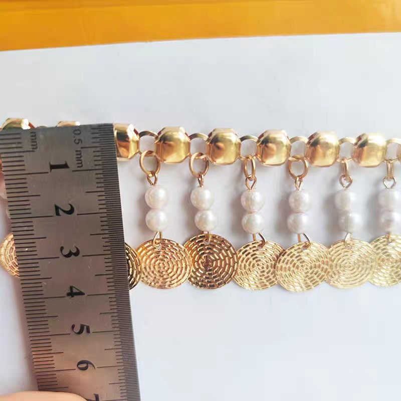 Frange faite à la main, de 91 cm de long et 4 cm de large, ornée de perles et de sequins métalliques dorés.