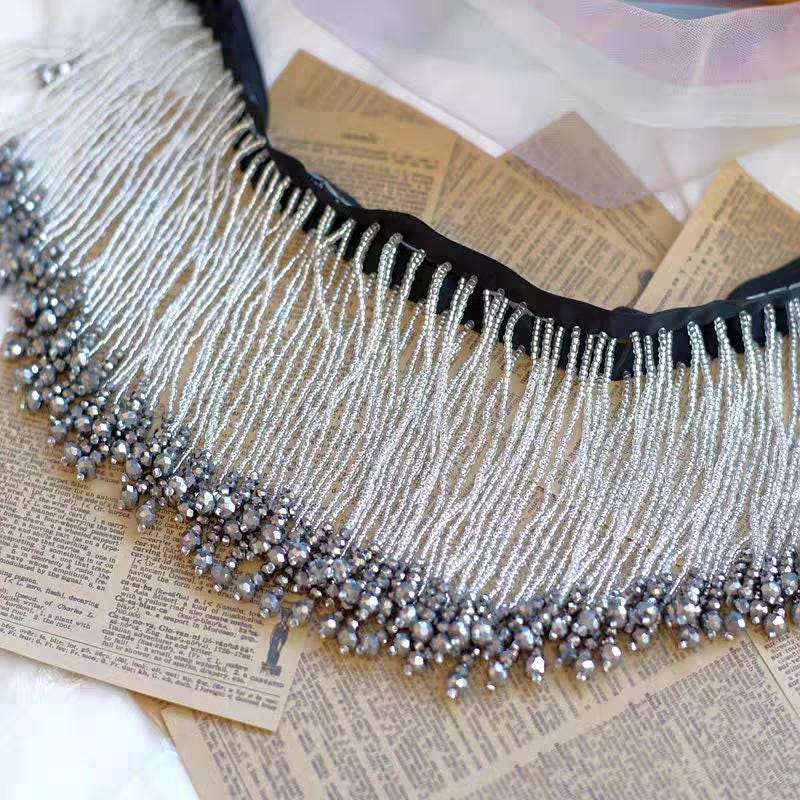 Frange perlée faite main de 90 cm de long et 10,5 cm de large, ornée de perles de rocaille et de perles de cristal. Idéale pour abat-jour, robe de mariée ou rideau.