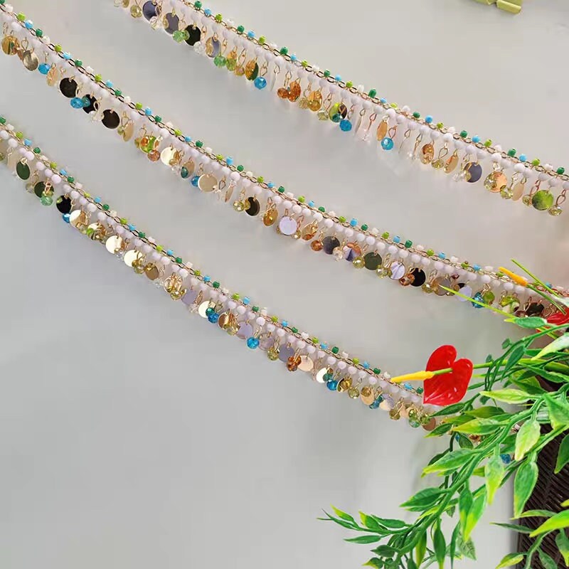 Handgemaakte kralenketting met franjes van kristallen kralen en metalen pailletten, 90 cm lang en 3 cm breed.