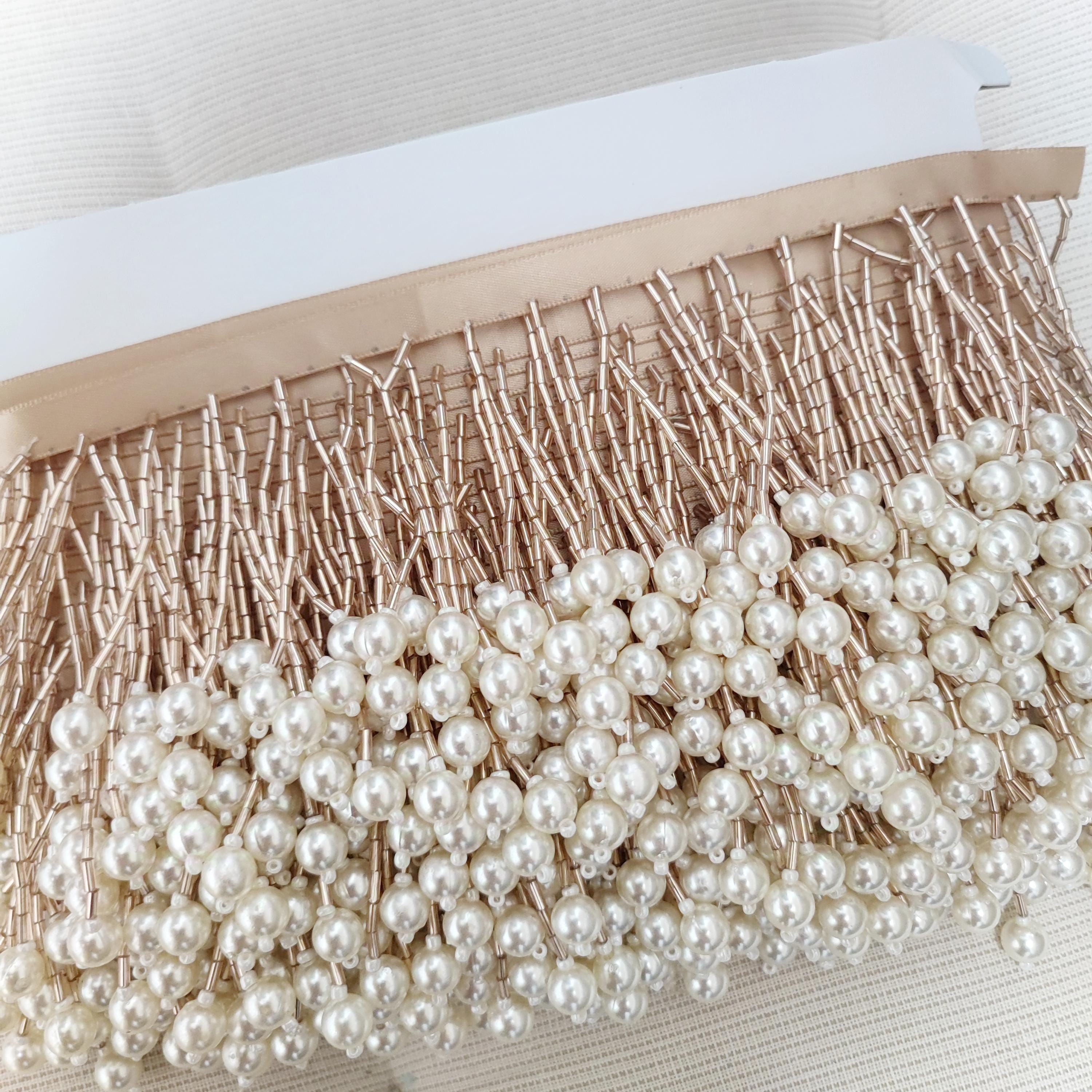 Frange perlée faite main de 90 cm de long et 8 cm de large, composée de perles tubulaires et de perles de culture. Idéale pour abat-jour, rideaux, robes, etc.